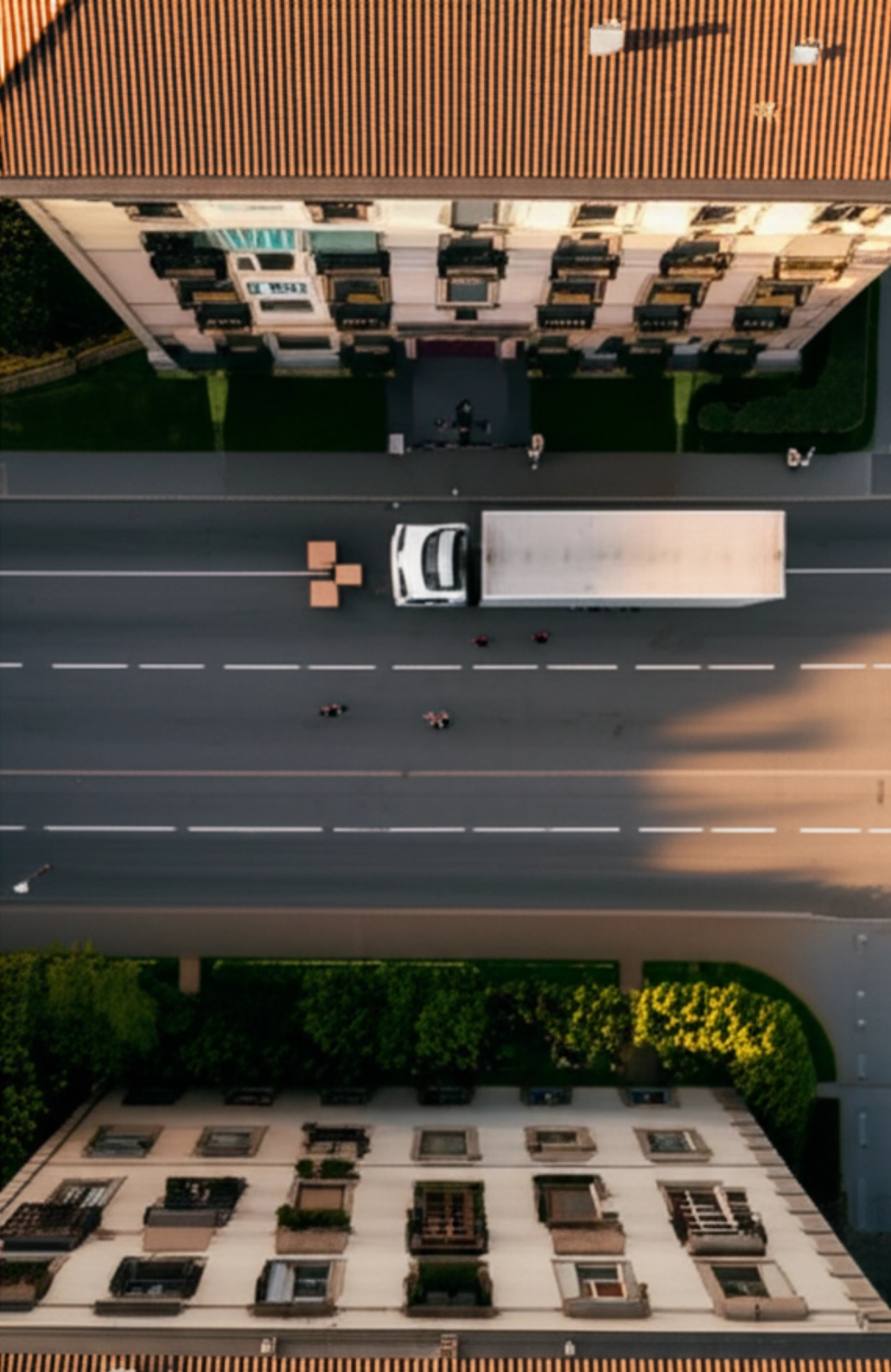 Vista aerea iperrealistica di un camion per traslochi e traslocatori caucasici in una strada residenziale di Milano, che mostra la logistica efficiente di un trasloco.